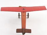 underside view of a red model of a small airplane on a white surface