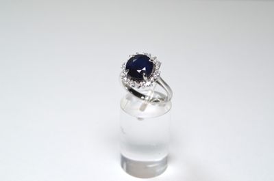 a ring with a blue stone in it sitting on a clear glass
