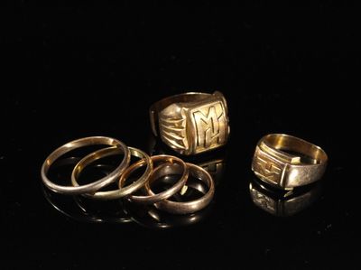 trois anneaux en or et deux anneaux en argent sur un fond noir