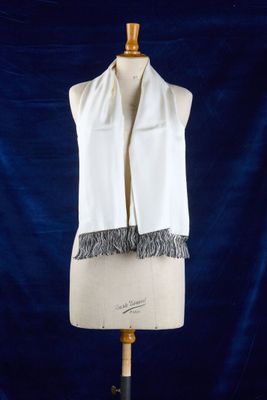 une écharpe blanche sur un mannequin, sur fond bleu