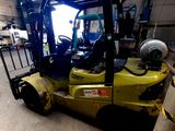 un chariot élévateur jaune garé dans un entrepôt