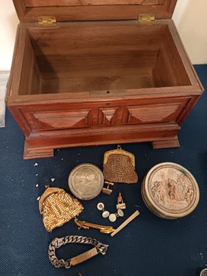a small wooden chest with a lot of things inside of it