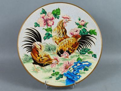 une assiette décorative ornée d'un coq et de fleurs