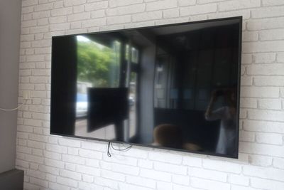 un grand téléviseur à écran plat fixé à un mur de briques