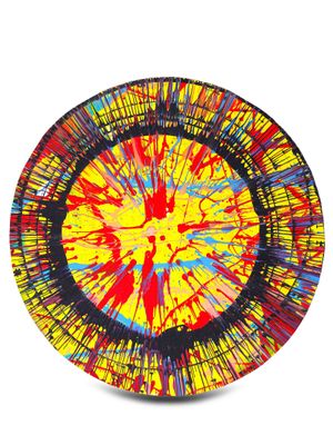 Peinture abstraite jaune, rouge, bleue et noire sur une assiette