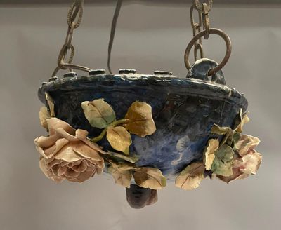a hanging planter with flowers and leaves on it