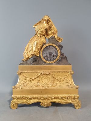 une horloge en or surmontée d'une statue