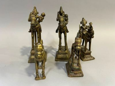 trois figurines en bronze représentant un homme et une femme à cheval