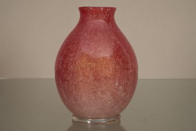 un vase rouge posé sur une table