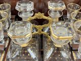 bottles and glasses on a tray on a table with gold trimming