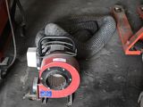 un ventilateur rouge posé par terre à côté d'une machine rouge