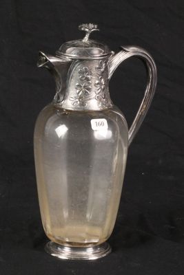an antique silver plated glass pitcher on a black background