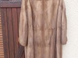 a fur coat hanging on a wall next to a wooden door