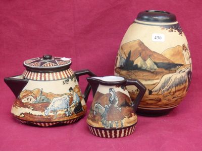 three pieces of pottery on display on a pink surface