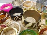 many different types of bracelets and bangles on the table