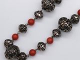 an image of a necklace with red beads on a white surface