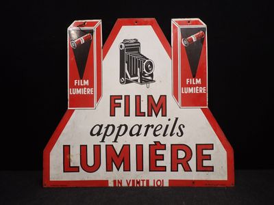 une vieille affiche publicitaire pour les appareils de cinéma Lumière, en rouge et blanc