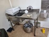 a kitchen with a sink and a trash can in it