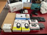 many boxes of headphones on a table with a keyboard