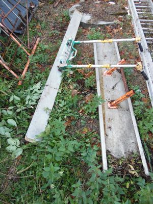 une échelle posée par terre dans l'herbe