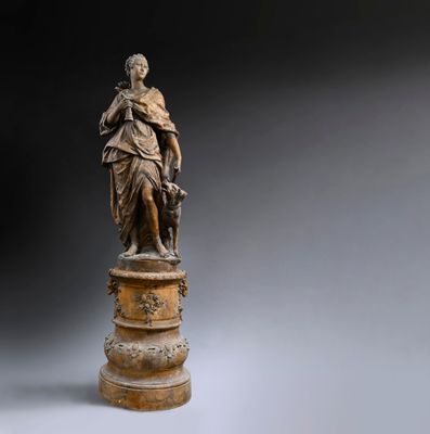 une statue en bronze représentant une femme tenant un enfant dans ses bras, posée sur un socle