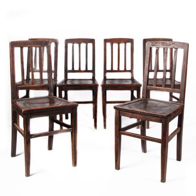 quatre chaises en bois sont alignées sur un fond blanc