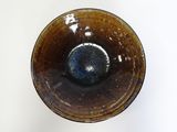 a brown and blue bowl on a white surface
