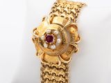 an image of a close up of a gold bracelet on a white pillow