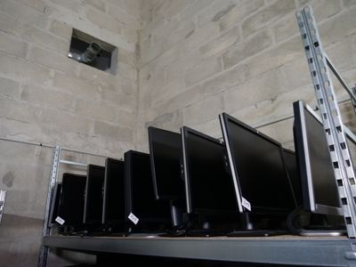 de nombreux écrans d'ordinateur posés sur une étagère dans une pièce