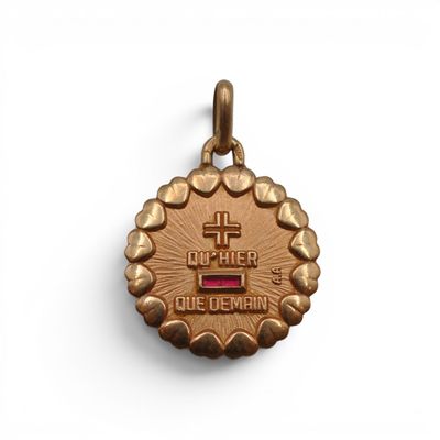 une petite médaille en or surmontée d'une croix