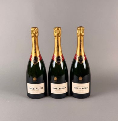 trois bouteilles de champagne sont alignées sur une surface grise