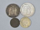 four different types of coins sitting on top of a white surface