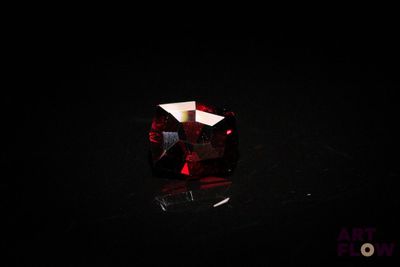 a close up of a red diamond on a black surface