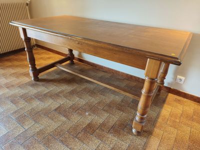 a wooden table that is sitting on a tile floor