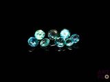 un gros plan sur un groupe de diamants bleus posés sur une surface noire