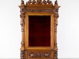 une vitrine ancienne en bois recouverte de velours rouge