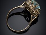 a close up of a gold ring with a blue topaz stone