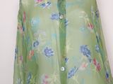 a green shirt with blue and pink flowers on it
