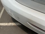 a white car parked in a parking lot with a parking meter in the background