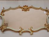 un miroir avec un cadre doré sur le mur