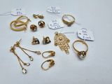 quelques bagues en or et d'autres bijoux sont posés sur une surface blanche