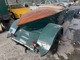 a green car with a surfboard on the back of it