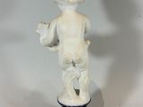 a small statue of a boy holding a tennis racket