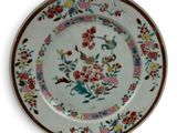 a plate with a floral design on it on a white surface