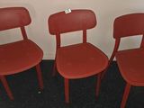 three red chairs sitting next to each other in a room