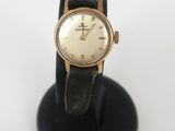 an image of a wrist watch on a black stand on a white surface