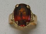 an image of a ring with a large garnet stone