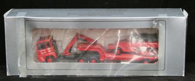 un camion rouge en jouet et un camion rouge dans une boîte