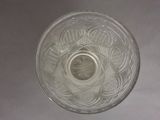 a glass bowl with a coin in it on a table