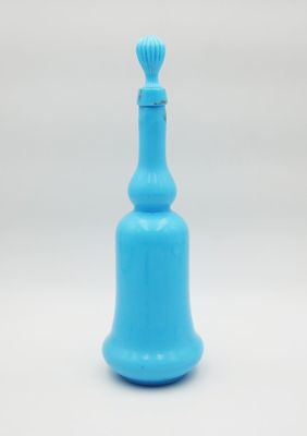 une bouteille en verre bleue munie d'une anse, sur fond blanc